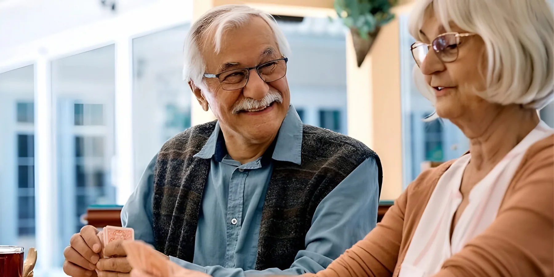 Two residents laughing over a game of cards