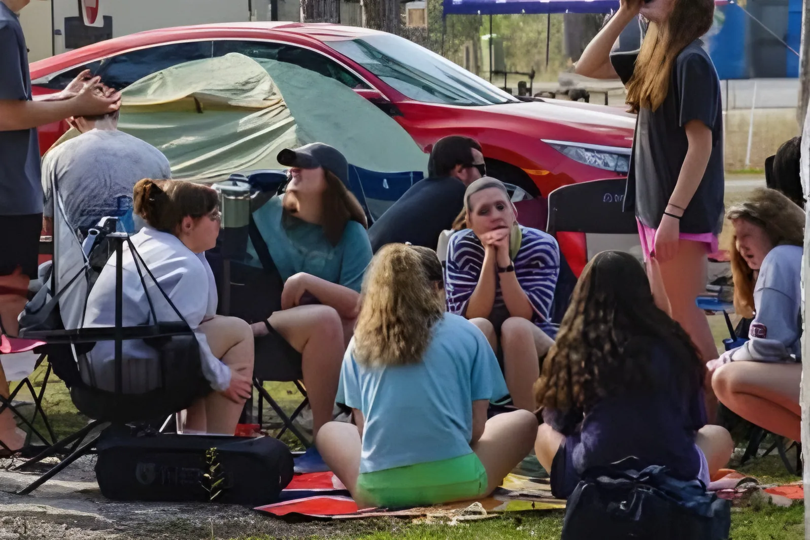 Club members sitting in a circle at a campsite