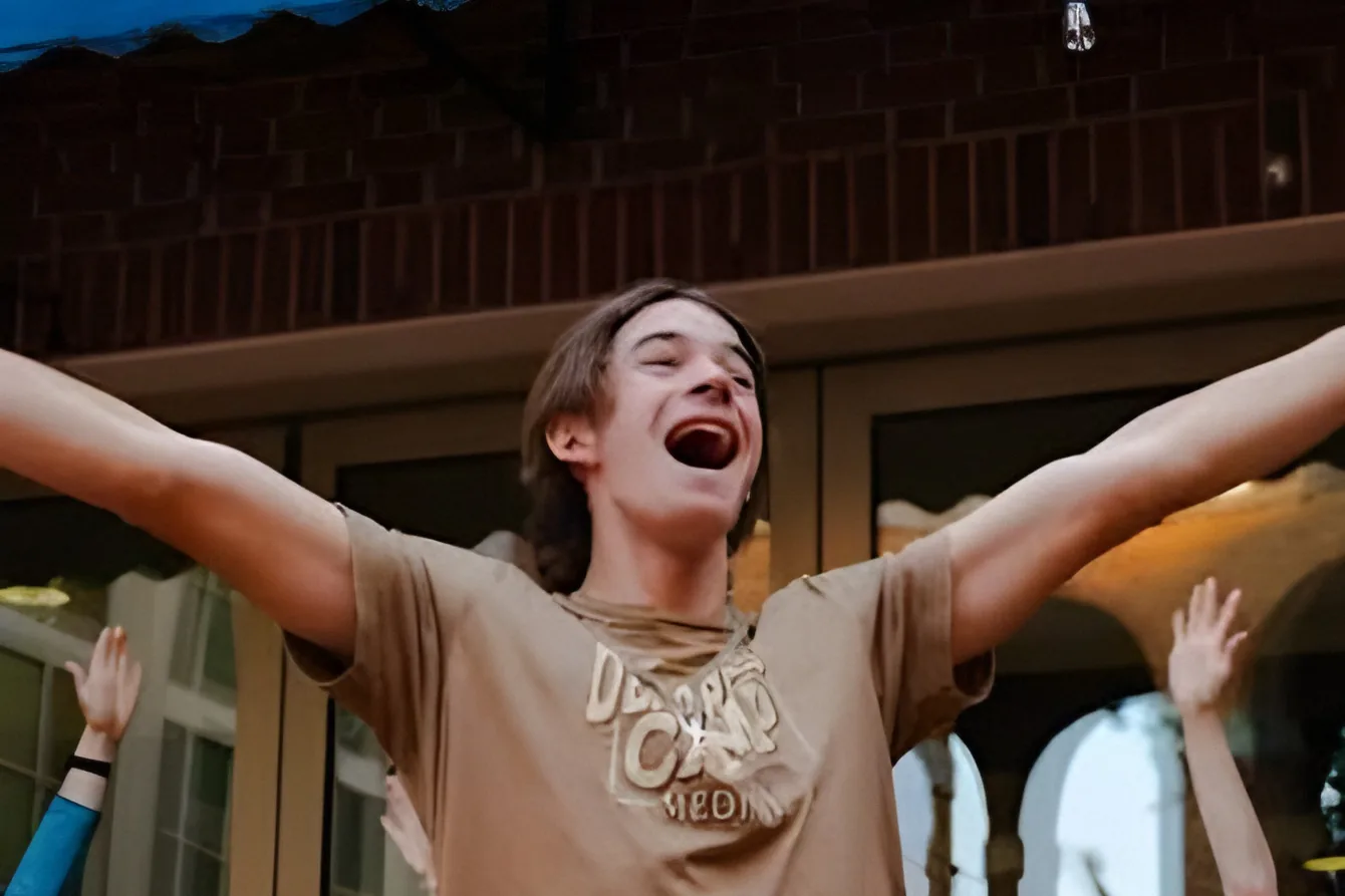 A club member cheering with both arms raised