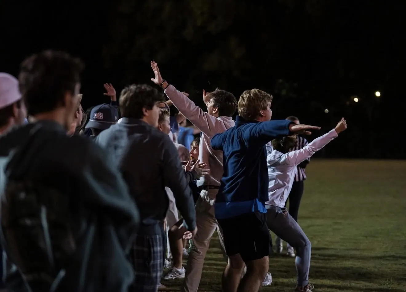 Students celebrating on the sideline during a night game at Samford