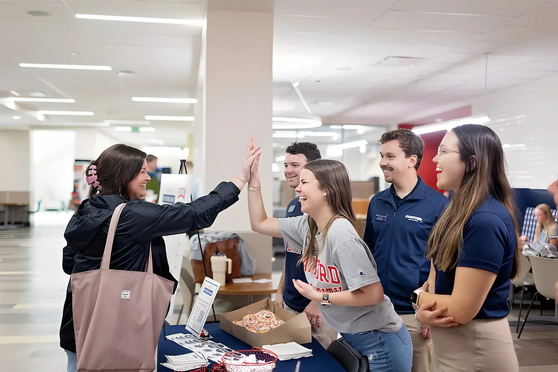 Students trading a high five at a Giving Day table